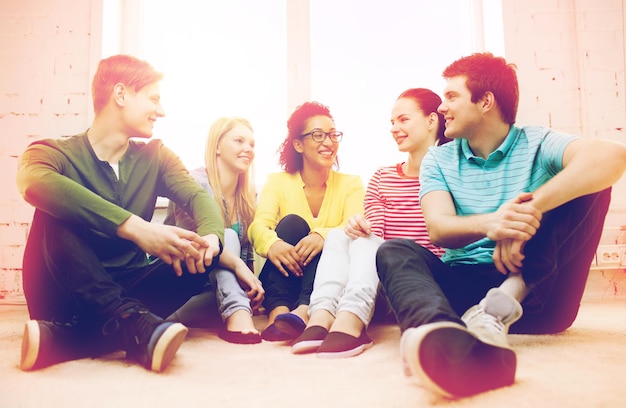 concepto de educación, ocio y felicidad - cinco adolescentes sonrientes divirtiéndose en casa