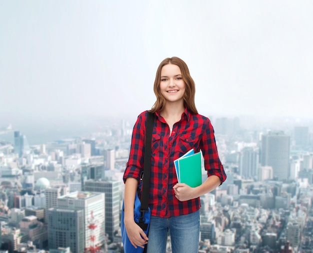 concepto de educación y personas - estudiante sonriente con bolsa para laptop y cuadernos