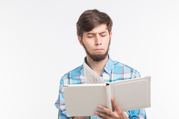 Concepto de educación, proceso y personas - joven leyendo un libro en serio.