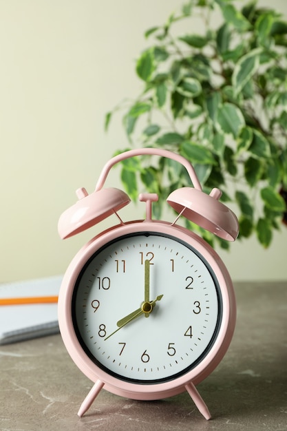 Concepto de educación con reloj despertador en mesa con textura gris