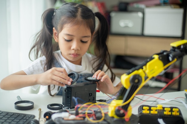 Concepto de educación STEM Diseño de robots para jóvenes asiáticas que aprenden