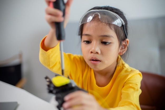 Concepto de educación STEM Los estudiantes asiáticos aprenden en casa codificando brazos robóticos en STEM matemáticas ingeniería ciencia tecnología código informático en robótica para conceptos de niños