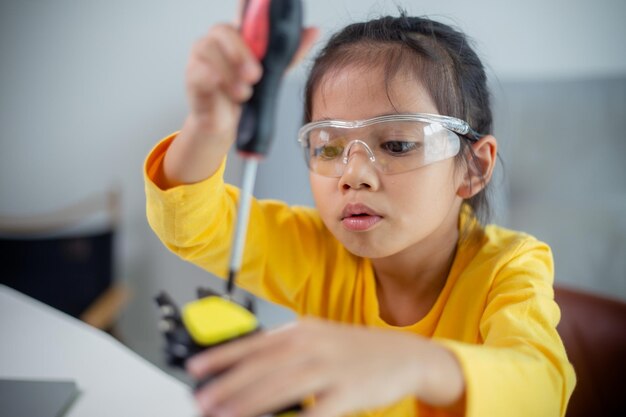 Concepto de educación STEM Los estudiantes asiáticos aprenden en casa codificando brazos robóticos en STEM matemáticas ingeniería ciencia tecnología código informático en robótica para conceptos de niños