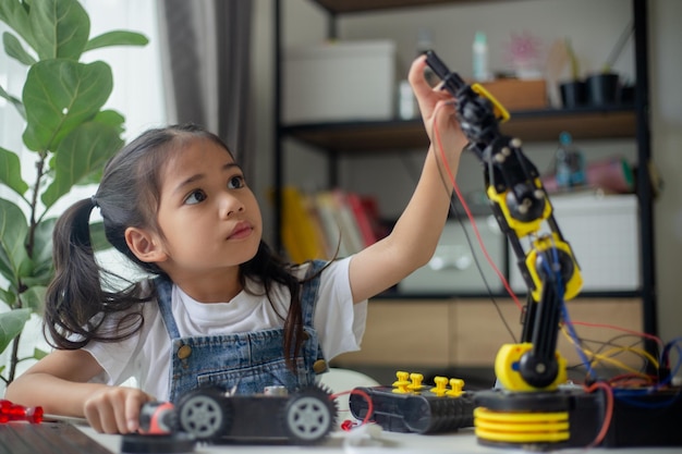 Concepto de educación STEM Niña joven asiática aprende diseño de robot