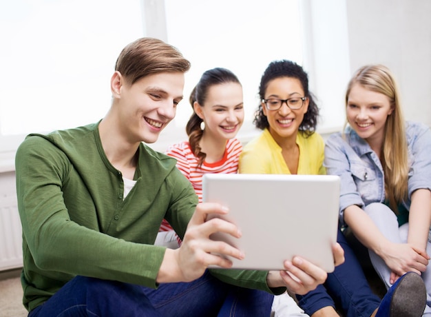 concepto de educación y tecnología - estudiantes sonrientes haciendo fotos con una computadora de tablet pc en casa