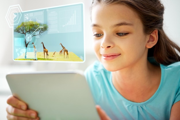 concepto de educación, tecnología y personas: primer plano de una chica sonriente con una tableta y animales salvajes en una pantalla virtual en casa