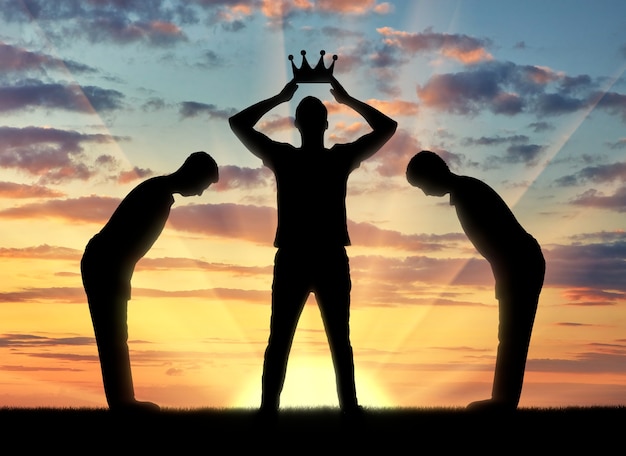 Foto concepto de egoísmo la silueta de un hombre egoísta viste su corona y los sirvientes se inclinan ante él