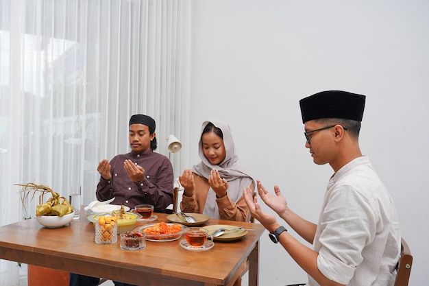Concepto de Eid Al-Fitr de personas que comen comida halal juntas durante el mes de fiesta del Ramadán en casa.