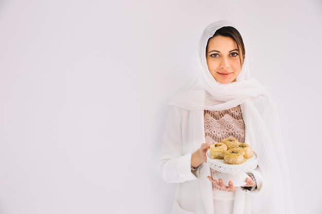 Foto concepto de eid con mujer sujetando pasteles árabes