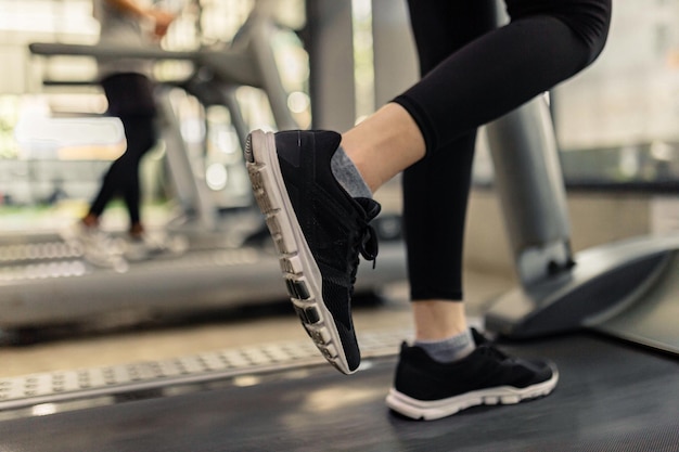 Concepto de ejercicio Las dos cintas de correr a cargo de dos jugadores, uno con zapatillas negras y el otro con zapatillas blancas.