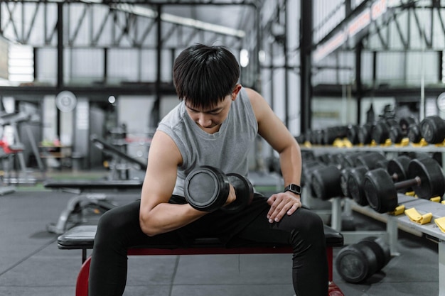 Concepto de ejercicio El tipo musculoso con top deportivo gris y pantalón negro