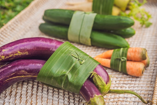 Concepto de embalaje de productos ecológicos verduras envueltas en una hoja de plátano como alternativa a un