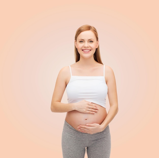 concepto de embarazo, maternidad y felicidad - futura madre feliz tocando su vientre