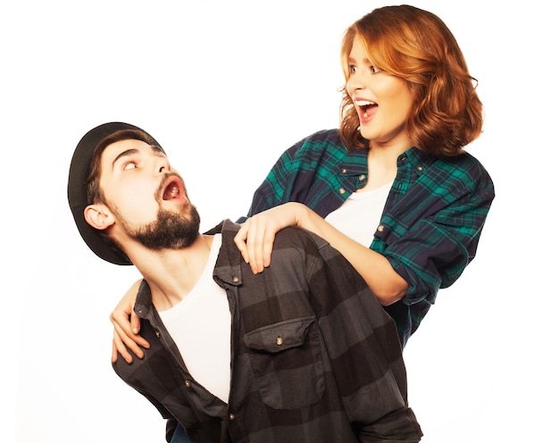 Concepto emocional, la felicidad y las personas: feliz pareja amorosa. Hombre joven que lleva a cuestas a su novia. Foto de estudio sobre fondo blanco. Fotos especiales de tonificación de moda.