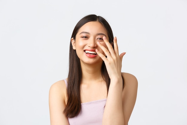 Concepto de emociones de belleza, moda y personas. Retrato de primer plano de una mujer asiática muy sonriente riendo coqueta, divirtiéndose en el evento de celebración