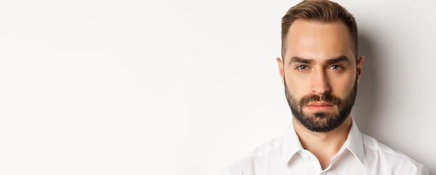 Foto concepto de emociones y personas headshot de un hombre guapo de aspecto serio con barba que parece confiado y