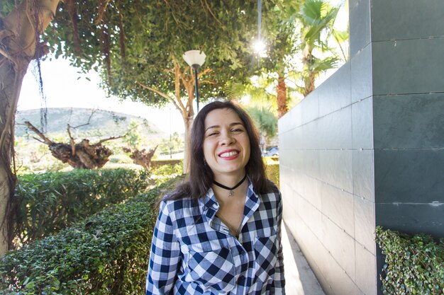 Concepto de emociones, verano y felicidad - Riendo a mujer joven divertida en ropa casual en la naturaleza.