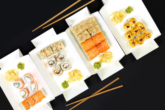 Concepto de entrega de comida japonesa. Conjunto de rollos de sushi con vista superior de pescado y queso