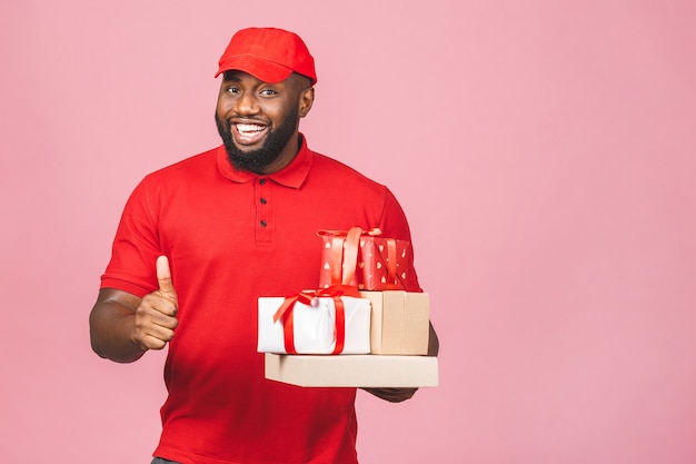 Concepto de entrega. Hombre negro afroamericano de entrega con paquetes y cajas de regalo. Pulgares hacia arriba.