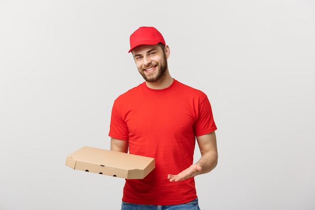 Concepto de entrega: joven haapy caucásico guapo repartidor de pizza con cajas de pizza