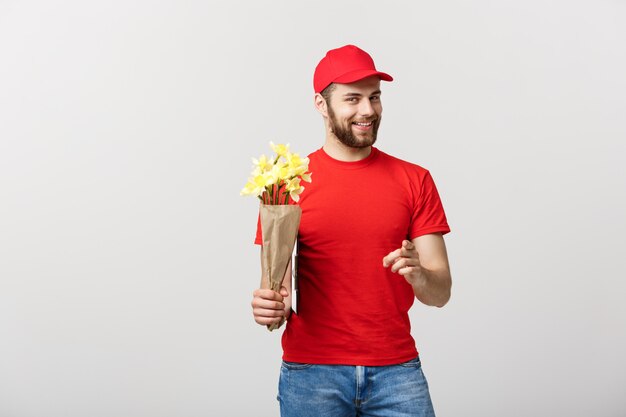 Concepto de entrega: Retrato de hombre feliz entrega de flores con hermoso ramo de flores