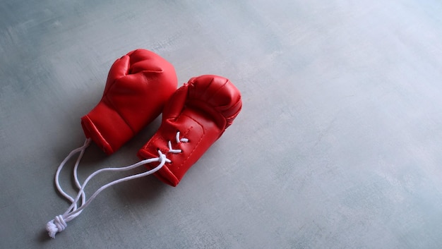 Concepto de entrenamiento deportivo Guantes de boxeo rojos en piso de concreto con espacio para copiar texto