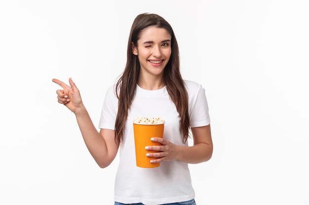 Concepto de entretenimiento, diversión y vacaciones. Retrato de joven linda descarada en camiseta, guiño y sonrisa