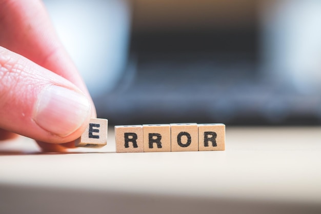 Concepto de error o error Cubos de madera con letras Error acostado en un concepto de computadora portátil para bloqueo de computadora
