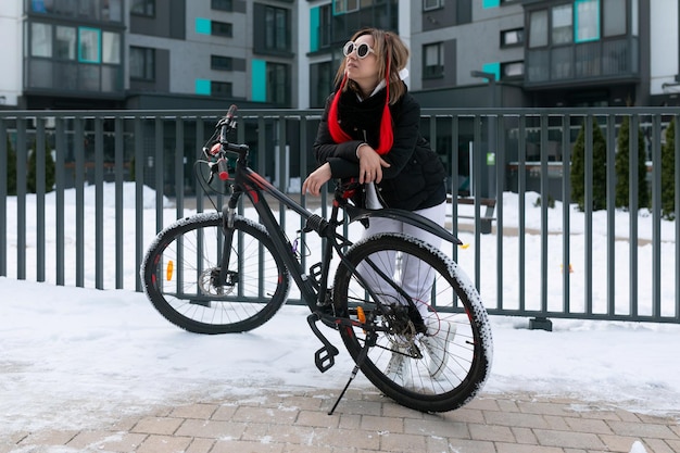 Concepto de estilo de vida mujer caucásica divirtiéndose mientras anda en bicicleta en invierno