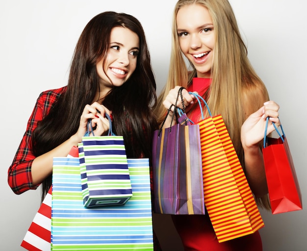 Concepto de estilo de vida y personas Dos mujeres jóvenes vestidas de rojo con bolsas de compras Gran venta