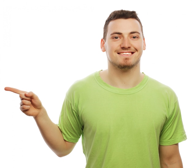 Concepto de estilo de vida y personas: joven sonriente feliz muestra algo en el espacio en blanco.