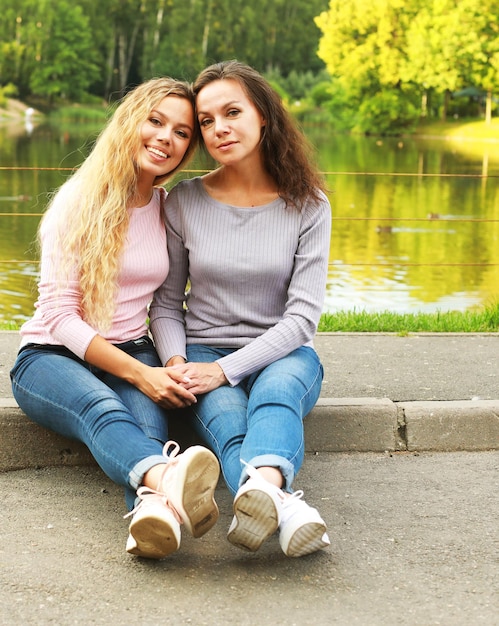 Concepto de estilo de vida y personas madre madura e hija adulta abrazándose en el parque