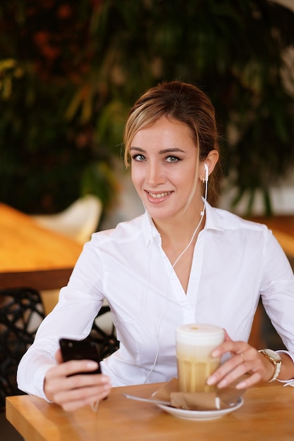 Concepto de estilo de vida y personas Mujer usando teléfono móvil en el café