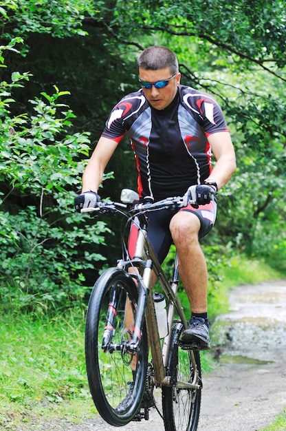 concepto de estilo de vida saludable y fitness con hombre en bicicleta que anda en bicicleta al aire libre