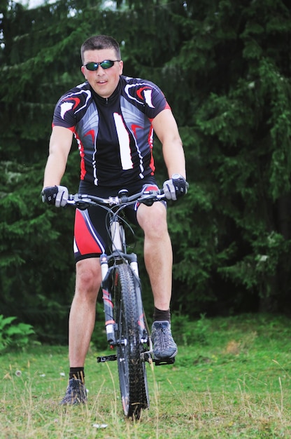 Foto concepto de estilo de vida saludable y fitness con hombre en bicicleta que anda en bicicleta al aire libre