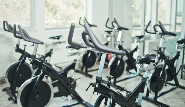 Concepto de estilo de vida saludable Lote de bicicleta estática en la clase de spinning sala vacía.