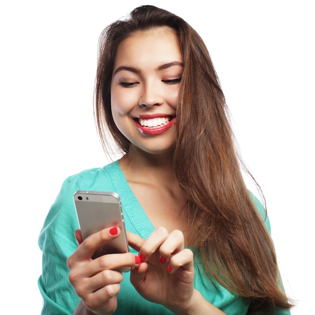 Concepto de estilo de vida y tecnología de la gente linda jovencita con camisa verde tomando selfies con su teléfono inteligente aislado en blanco