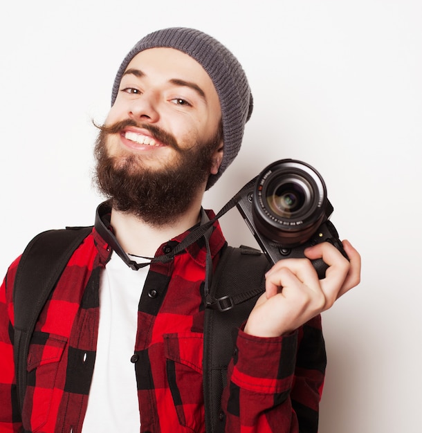 Concepto de estilo de vida, tecnología y personas: fotógrafo profesional. Retrato de joven confiado en camisa sosteniendo la cámara sobre un espacio en blanco