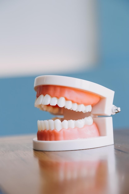 Concepto de estomatología retrato parcial de niña con dientes blancos fuertes mirando a la cámara y dedos sonrientes cerca de la cara Primer plano de una mujer joven en el estudio del dentista en el interior