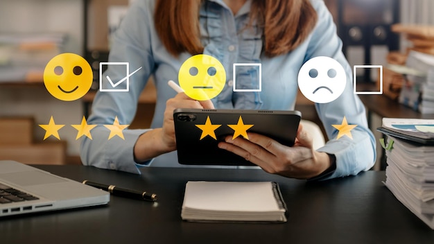 Foto concepto de evaluación del servicio al cliente empresaria presionando la cara sonrisa emoticono mostrar en pantalla virtual en tableta y teléfono inteligente en officexa