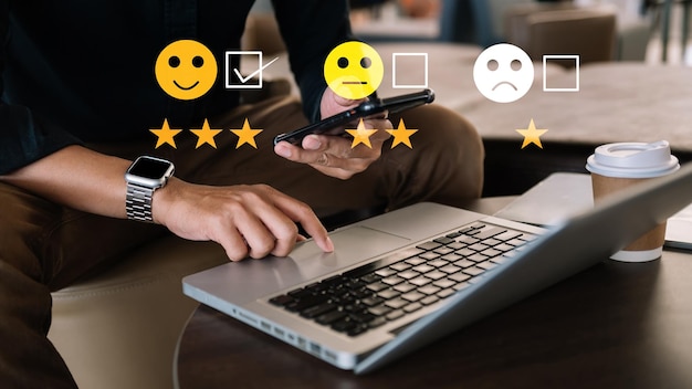 Concepto de evaluación del servicio al cliente Empresario presionando el espectáculo de emoticonos de sonrisa en la pantalla virtual en la tableta y el teléfono inteligente