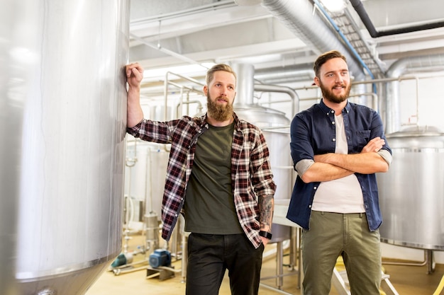 concepto de fabricación, negocios y personas: hombres en cervecería artesanal o planta de cerveza