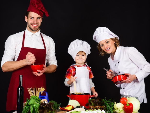 Concepto de familia amistosa familia feliz en la cocina comida sana en casa adorable niño sonriente en chef