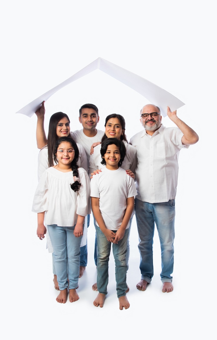 Foto concepto de familia y bienes raíces indio - familia asiática multigeneracional con modelo de casa de papel con llaves contra la pared blanca
