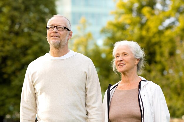 concepto de familia, edad, turismo, viajes y personas - pareja mayor en el parque de la ciudad