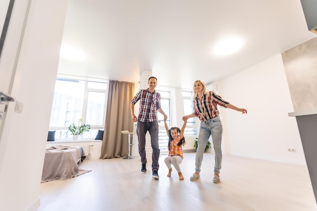 Concepto de familia: Familia joven feliz en el nuevo apartamento de ensueño y plan interior