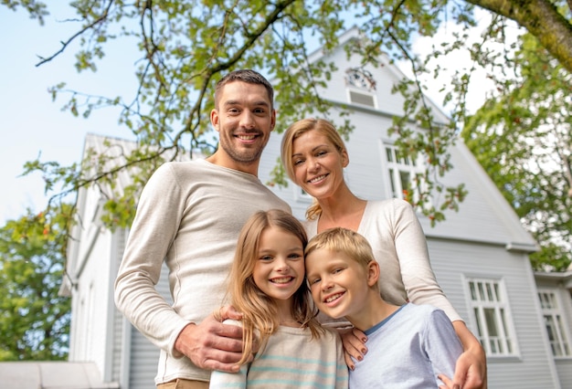 concepto de familia, felicidad, generación, hogar y personas - familia feliz parada frente a la casa al aire libre