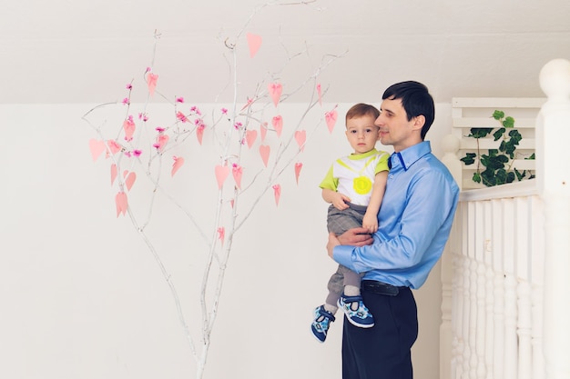 Concepto de familia, infancia, paternidad, actividad y personas - padre feliz e hijo pequeño jugando en casa.