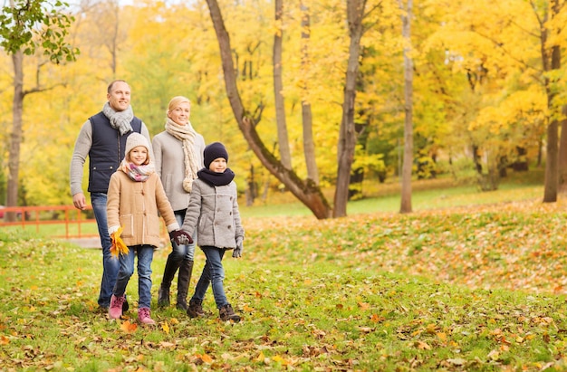 Concepto de familia, infancia, temporada y personas - familia feliz en el parque otoño