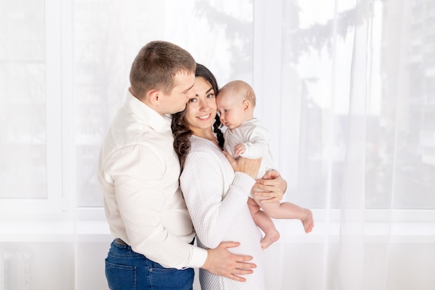 Concepto de una familia joven feliz, estilo de vida, padres con un bebé recién nacido en sus brazos